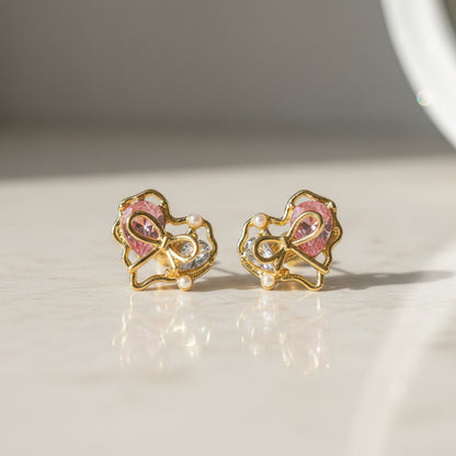 Crystal Bow Heart Earrings on marble surface