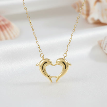 Gold Dolphin Heart Necklace with dolphin heart pendant on a light background