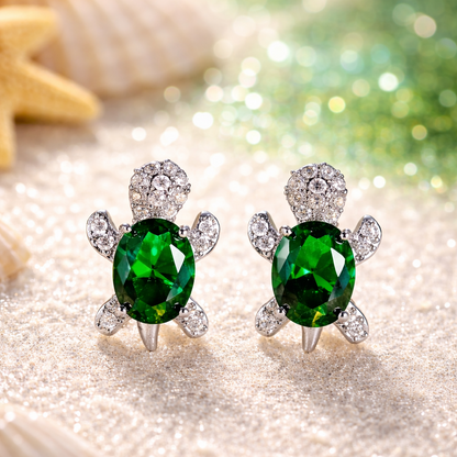 Emerald Green Crystal Turtle Earrings on a glittery surface