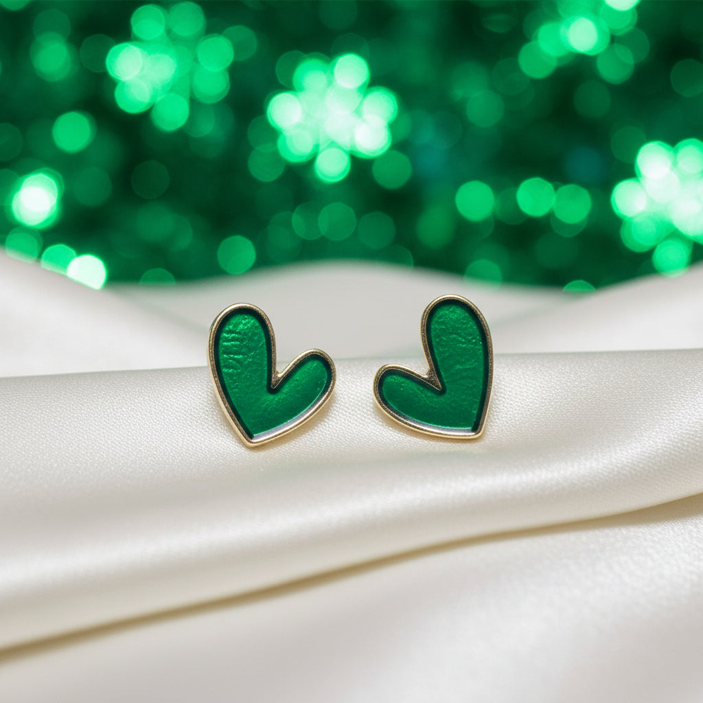 Evergreen Heart Earrings on a white surface with a green blurred background