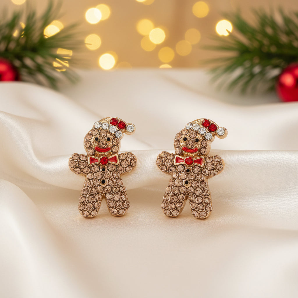 A pair of Gingerbread Man Pavé Earrings with gold-tone metal, brown rhinestones, and red crystal accents on a white background.