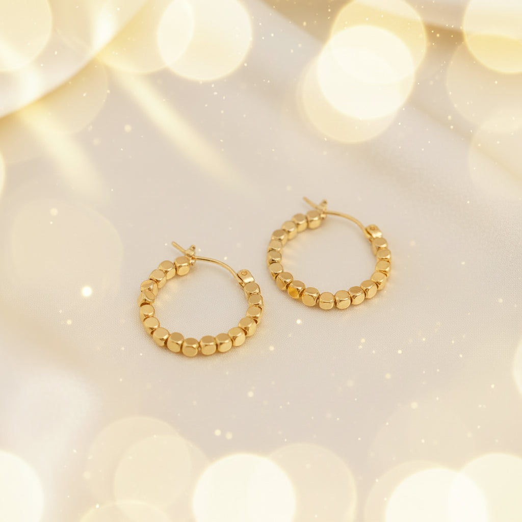 Gold Bead Accent Hoop Earrings on a beige fabric background