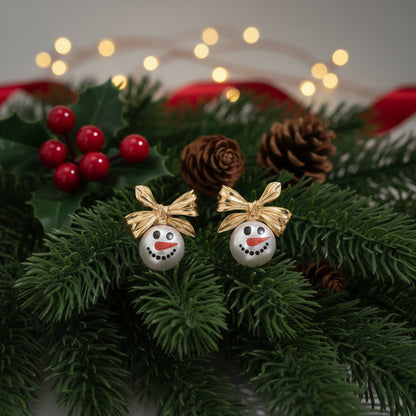 Golden Bow Snowman Earrings on pine