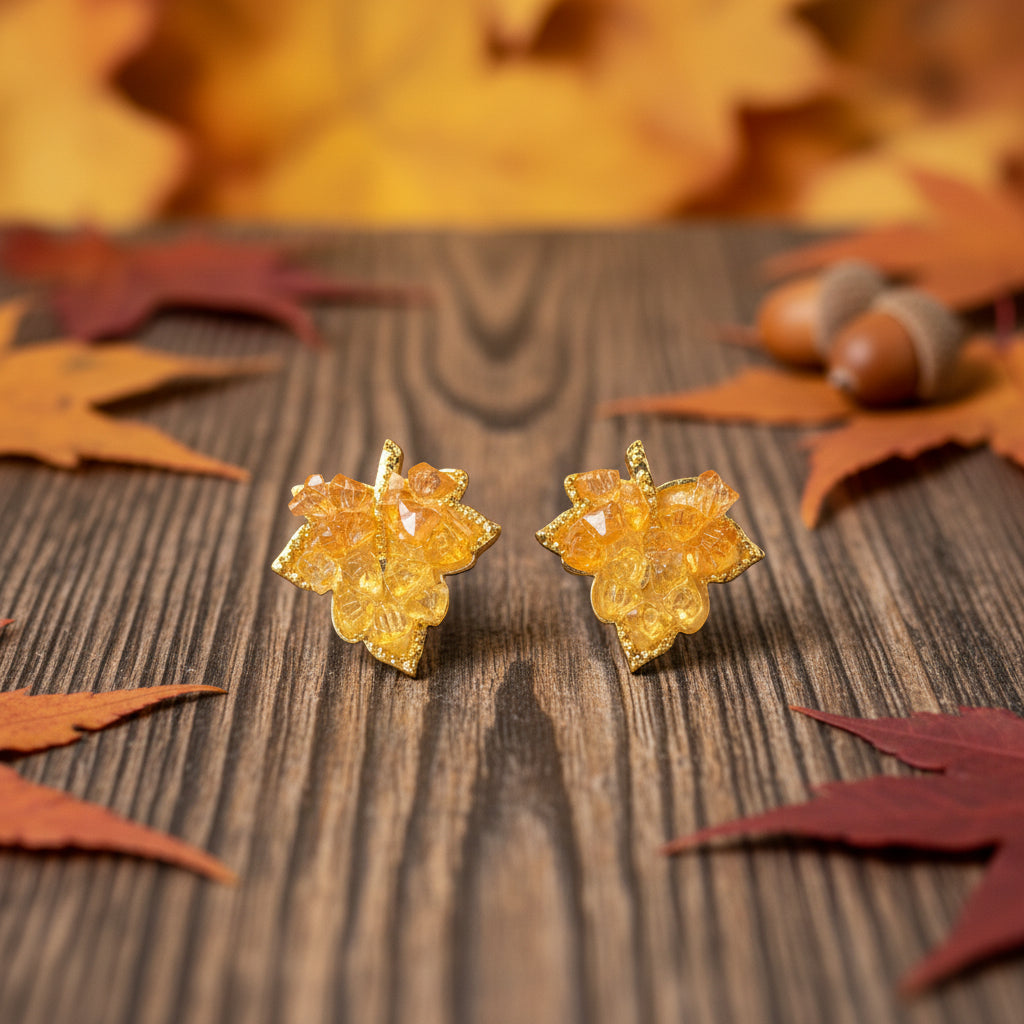 Golden Maple Leaf Earrings on wood