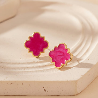 Hot Pink Clover Earrings on a beige stone surface