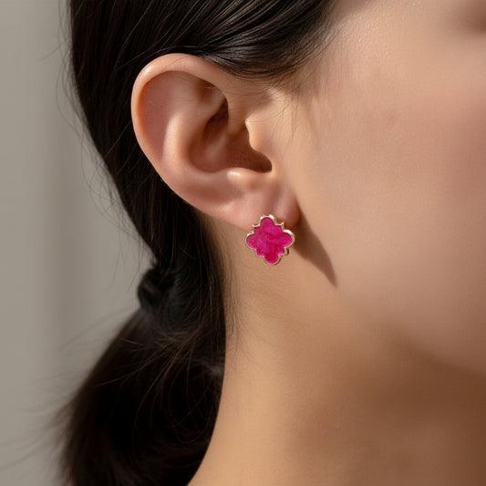 Close-up of a person wearing Hot Pink Clover Earrings with a blurred natural background
