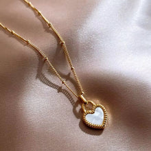 Load image into Gallery viewer, Gold necklace with a heart-shaped pendant on a beige fabric background