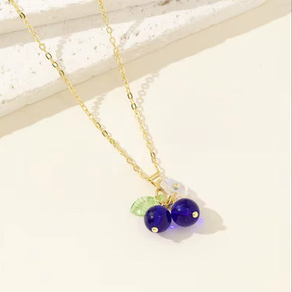 Necklace with purple beads and a green leaf charm on a light background