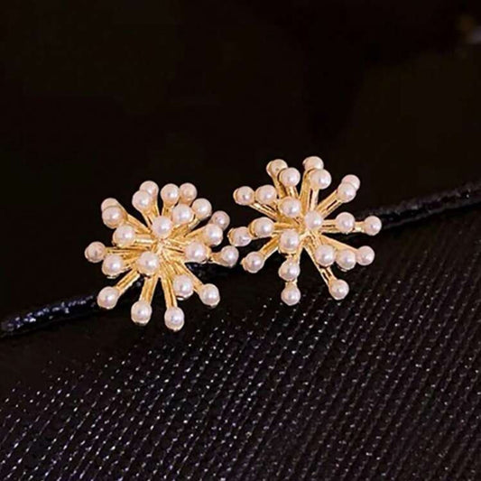 Pair of gold and pearl flower-shaped hair clips on a black background