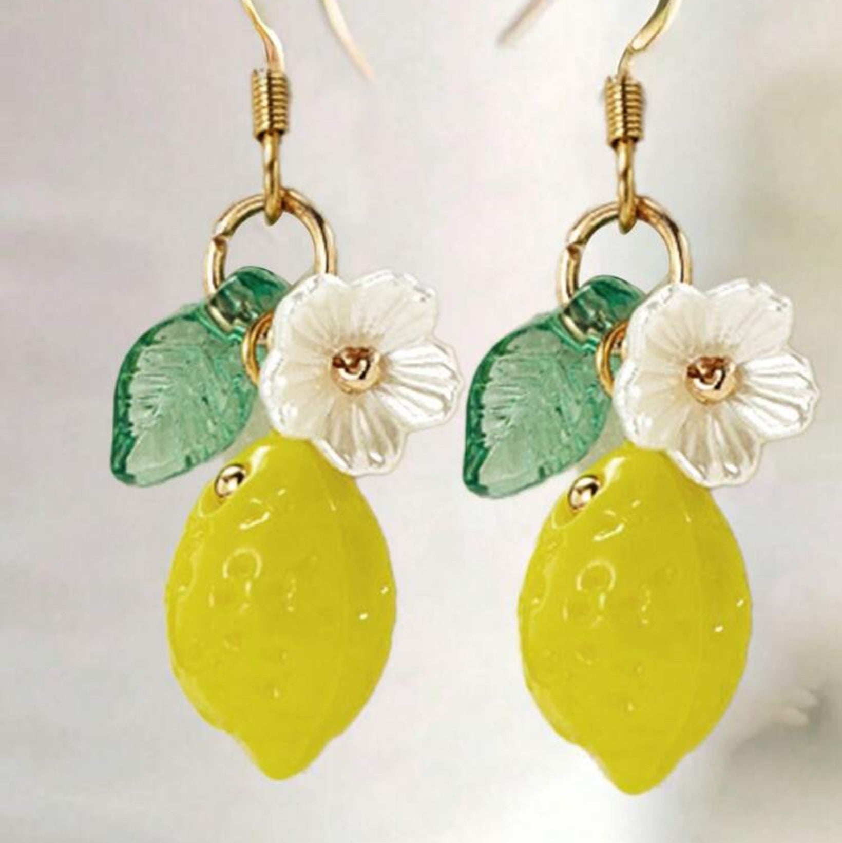 Lemon and flower earrings on a white background