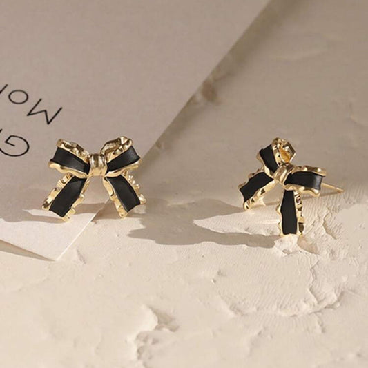 Black & Gold Bow Earrings with black centers on a light background