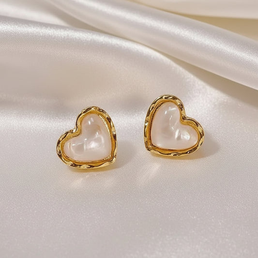 Gold & White Opalescent Heart Earrings with gold frames on a light background