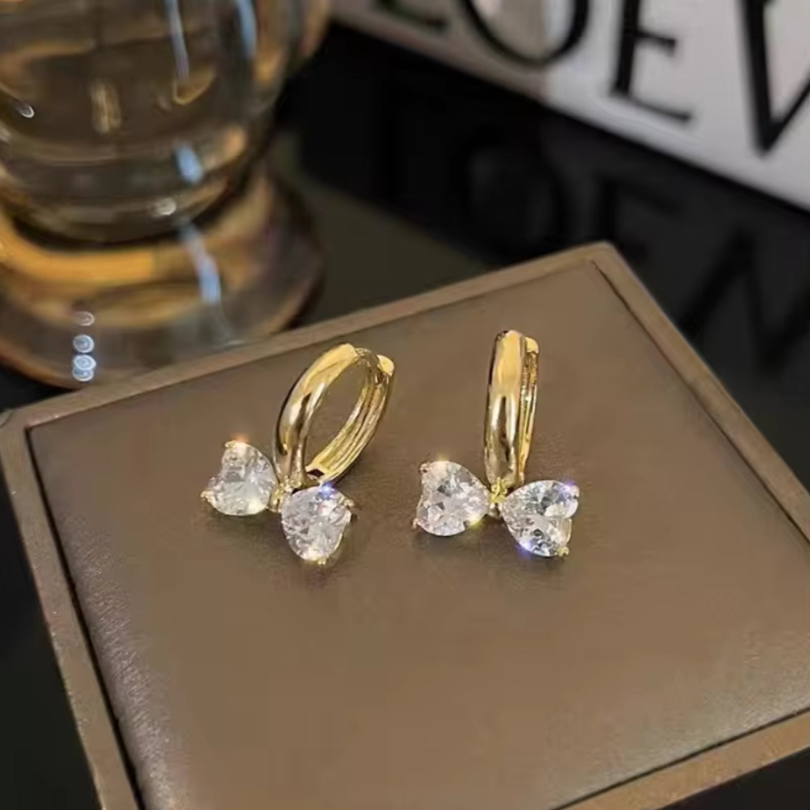 Gold Zircon Bow Hoop Earrings on a brown box