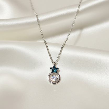 Midnight Star Halo Necklace with star and round pendant on a satin surface