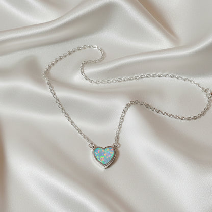 Iridescent Opal Heart Necklace on a silver chain against a light gray background