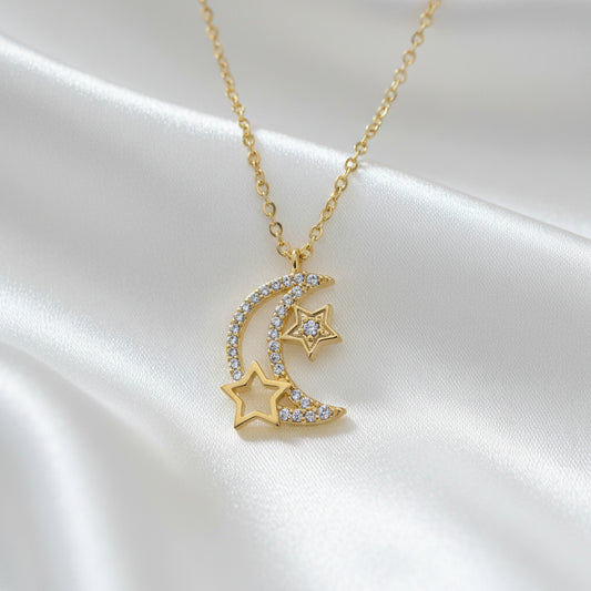 Gold necklace with star and moon pendant on a light blue background