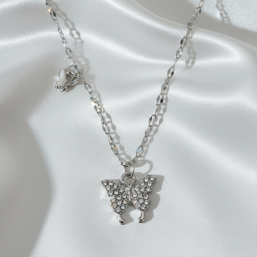 Silver necklace with angel wing pendants on a white background