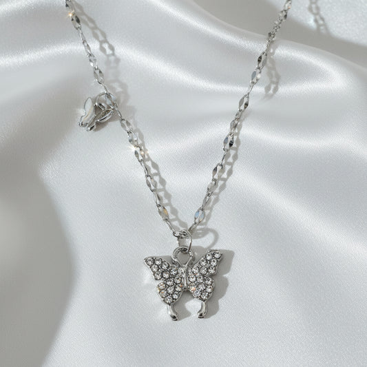 Silver necklace with angel wing pendants on a white background