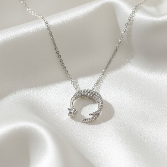 Silver necklace with moon and star pendant on a light blue background with 'Jewelry' text.
