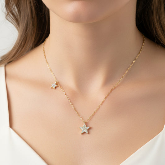 Gold Double Star Necklace with star pendants on a light blue background