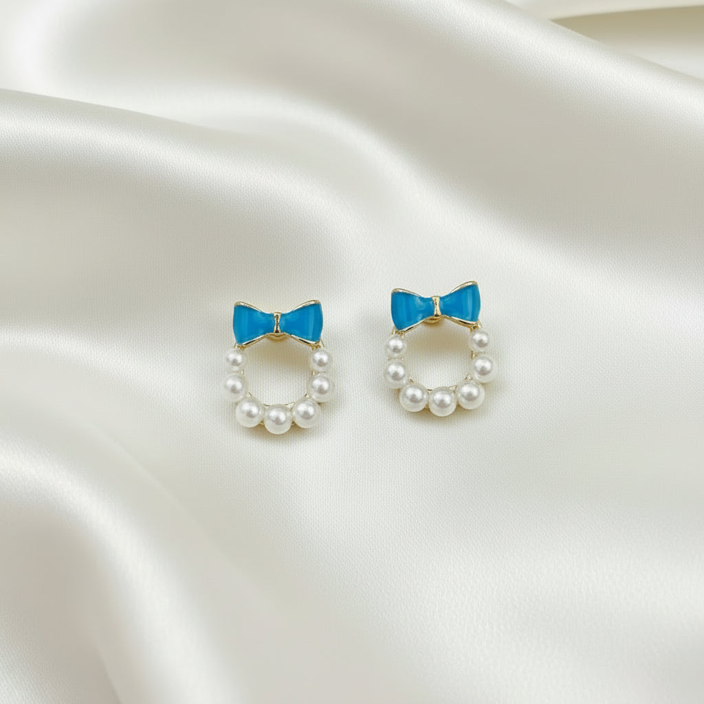 Blue Bow Pearl Wreath Earrings on a satin background