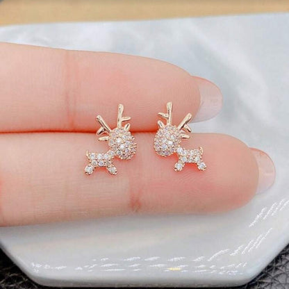Zircon Deer Earrings with clear gemstones on a finger.
