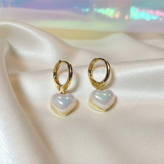 Iridescent Heart Drop Earrings with heart-shaped opalite stones on a satin surface