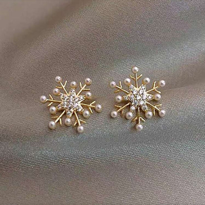 Snowflake Pearl Earrings with pearl and crystal details on a gray fabric background