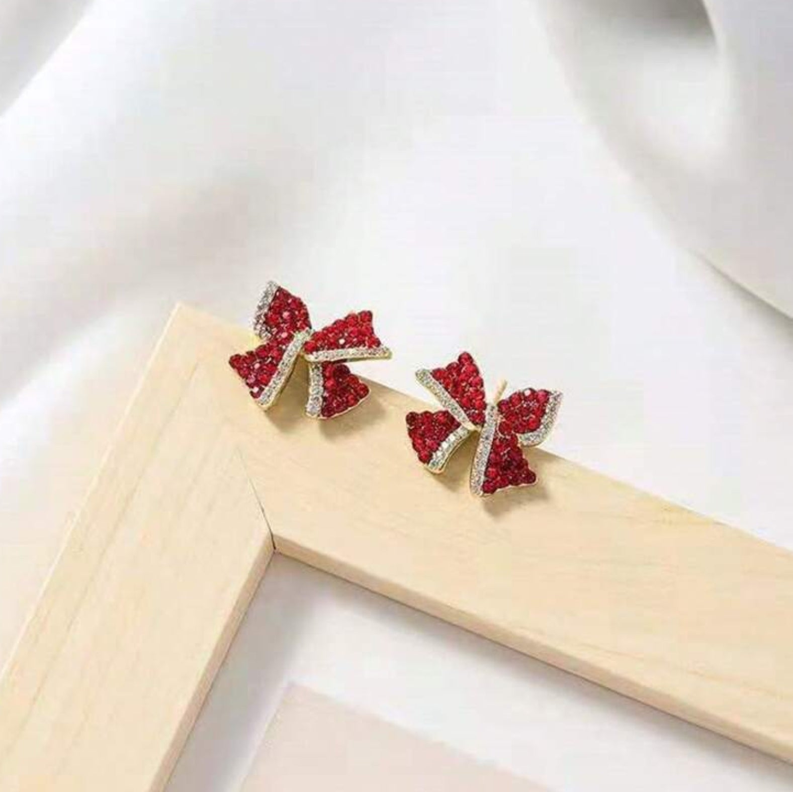 Red Bow Earrings with red gemstones on a white background