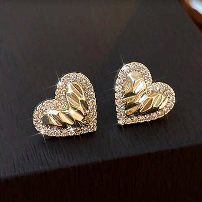 Gold Shimmer Heart Earrings with intricate designs on a dark surface