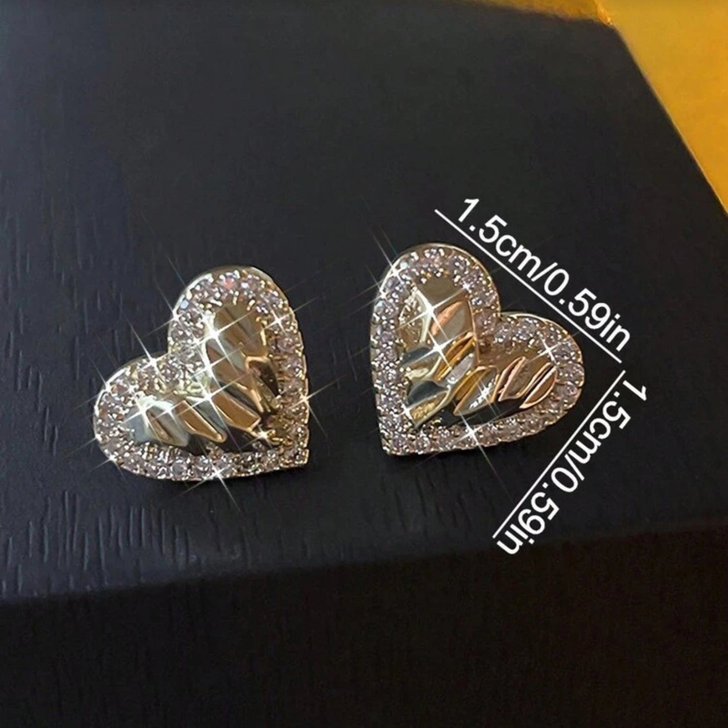 Gold Shimmer Heart Earrings with gold and silver design on a dark background