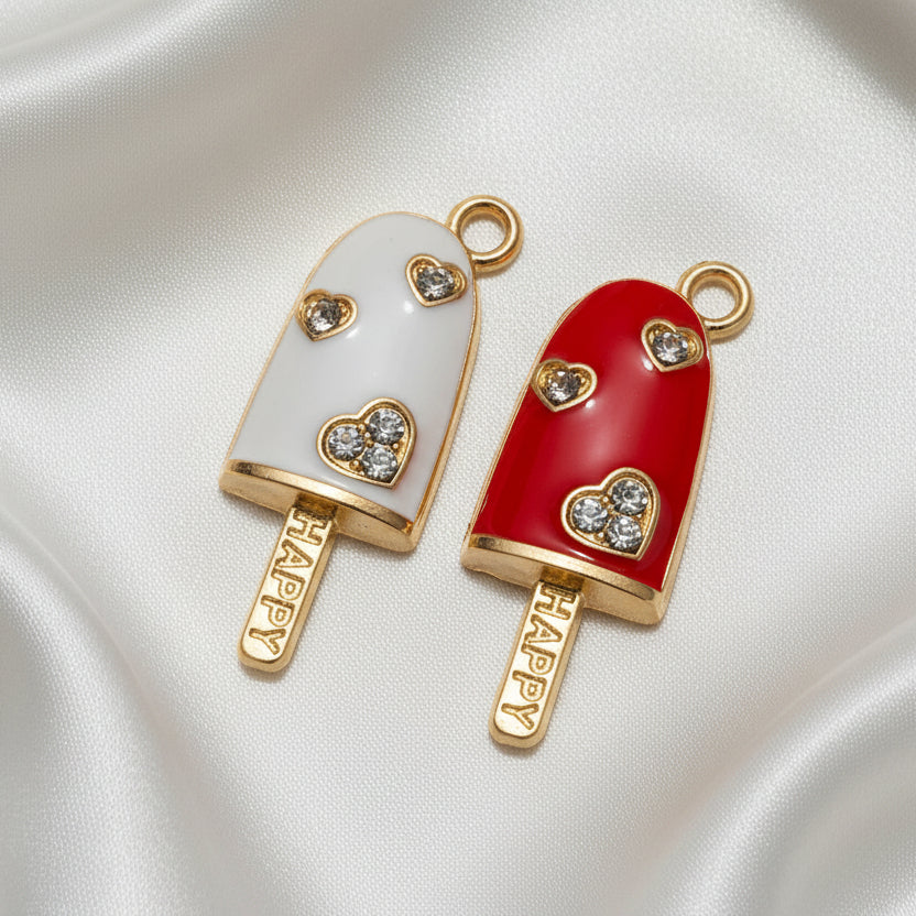 Cherry Cream Popsicle Duo (White & Red) ice cream popsicle-shaped charms, one white and one red, on a satin background.