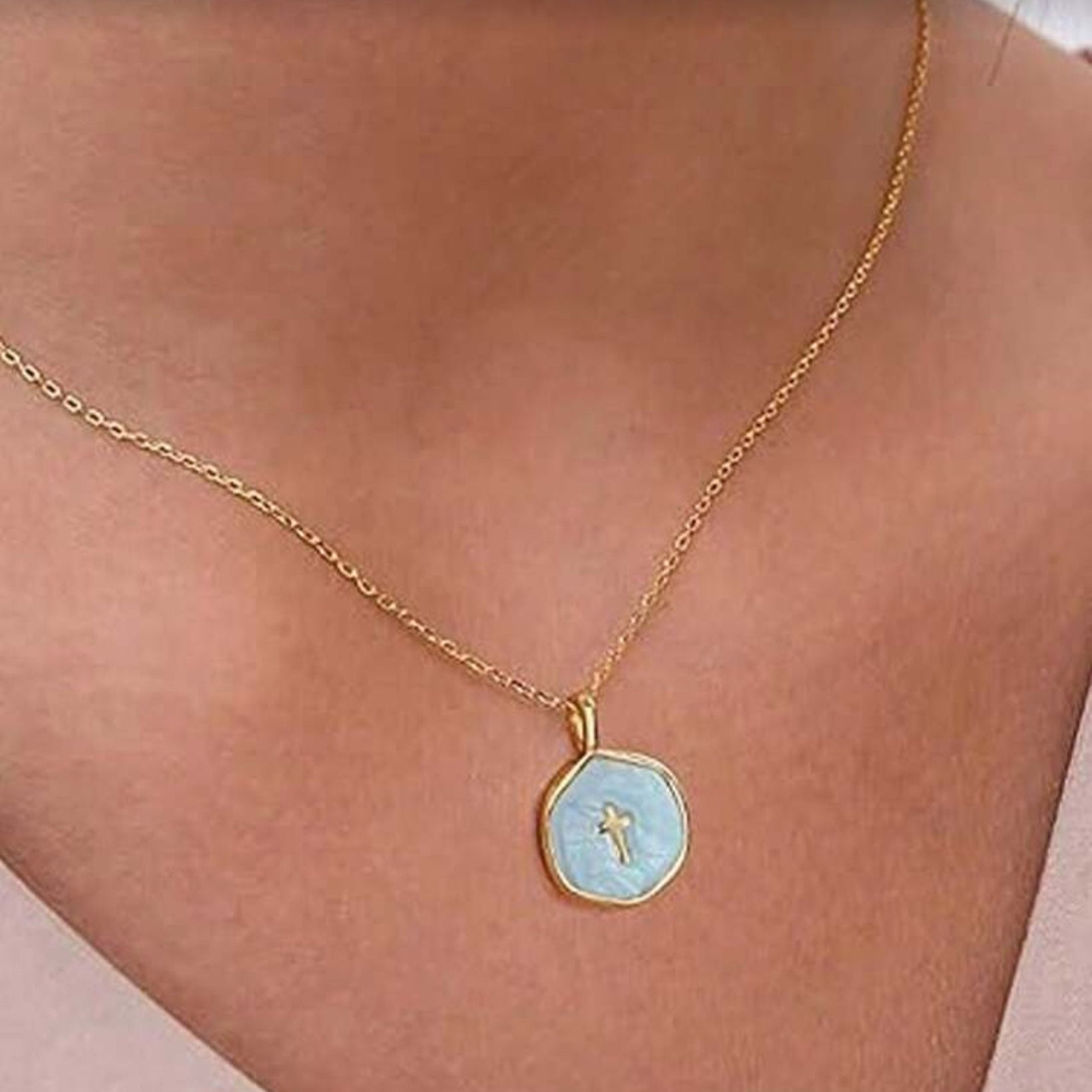 Walk in Faith Enamel Cross Necklace with a light blue pendant on a person's neck