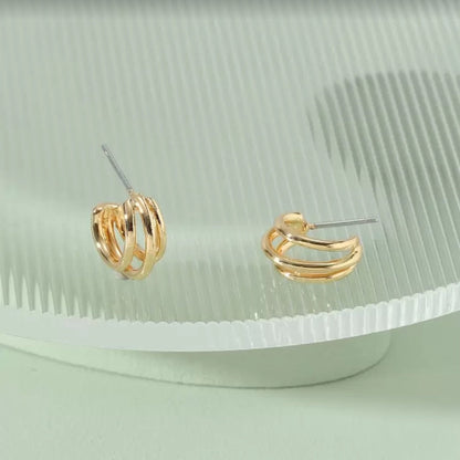 Triple Band Gold Hoop Earrings on a light green background
