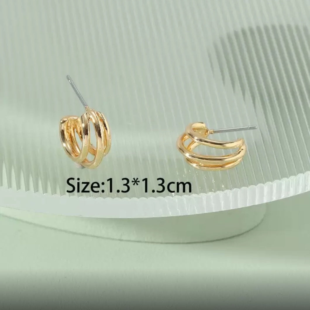 Triple Band Gold Hoop Earrings on a green textured surface with size label.