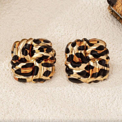 Leopard Square Knot Earrings on a textured surface