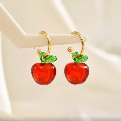 Red Apple Hoop Earrings with gold hooks on a beige background