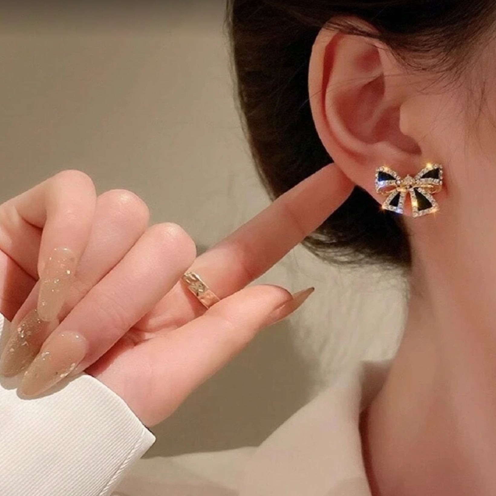 Person wearing Black Bow Rhinestone Earrings with a neutral background