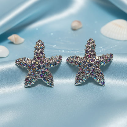 Iridescent Starfish Sparkle Earrings with colorful gemstones on a white stand.