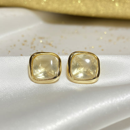 Pearl Square Stud Earrings on light fabric background