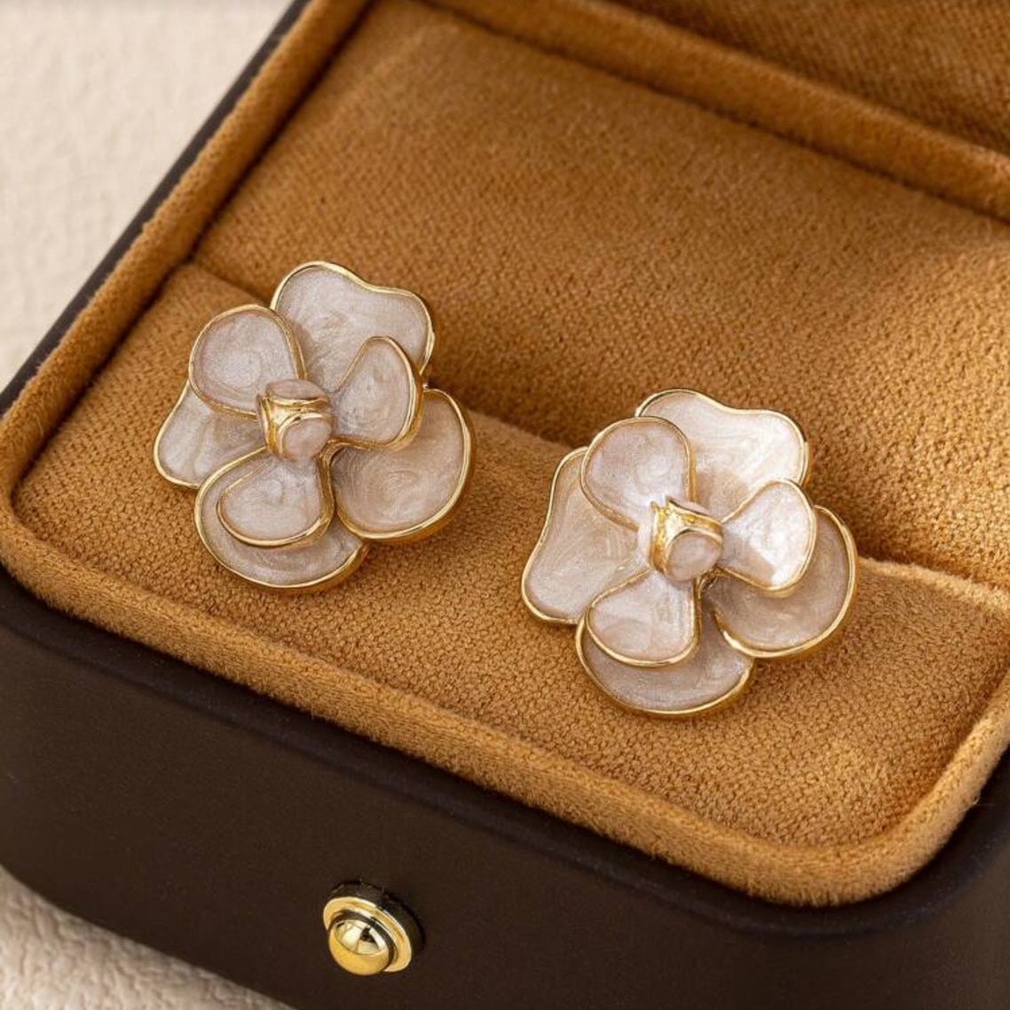 White Enamel Flower Earrings on a brown jewelry box