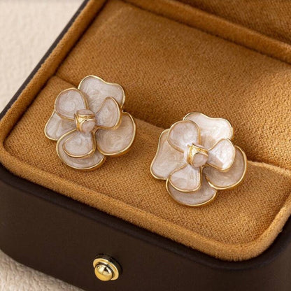 White Enamel Flower Earrings on a brown jewelry box