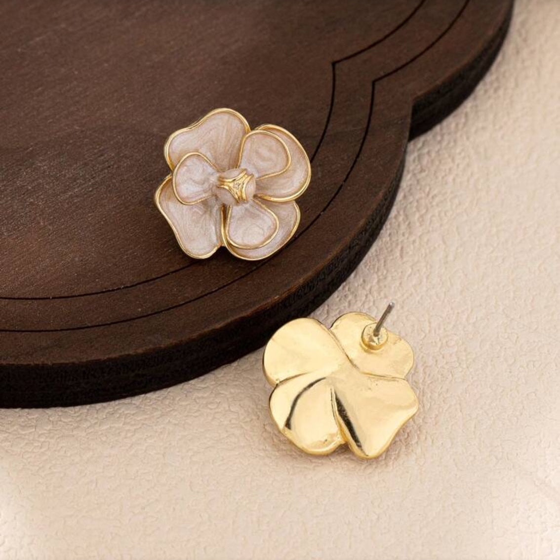 White Enamel Flower Earrings on a wooden surface