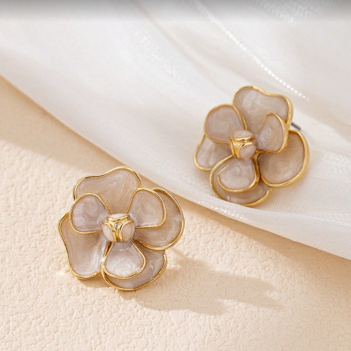 Pair of White Enamel Flower Earrings on a soft beige background