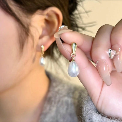 Close-up of a person wearing Gold Pearl Teardrop Earrings