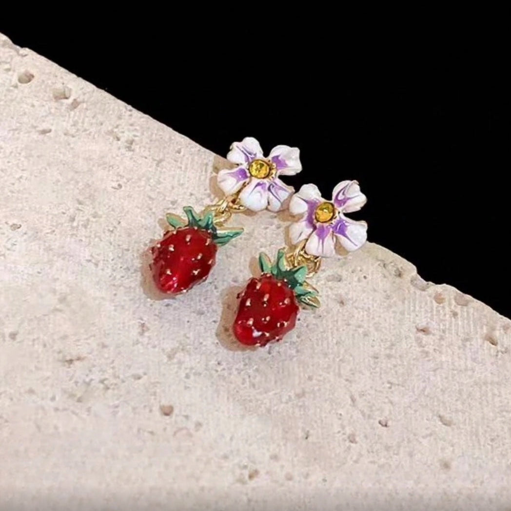 Pair of Blossom Strawberry Drop Earrings on a stone surface