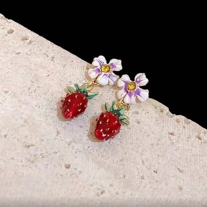 Pair of Blossom Strawberry Drop Earrings on a stone surface
