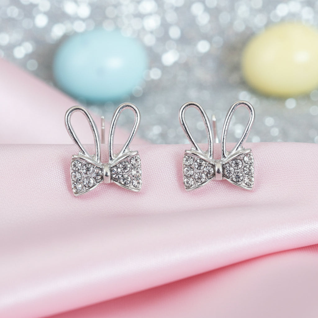 Silver Sparkle Bunny Bow Earrings on pink fabric