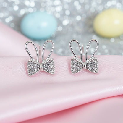 Silver Sparkle Bunny Bow Earrings on pink fabric