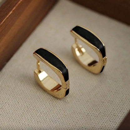 Black Enamel Hoop Earrings on a textured surface